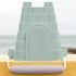 Green sandcastle mold on a yellow surface with a blurred beach background